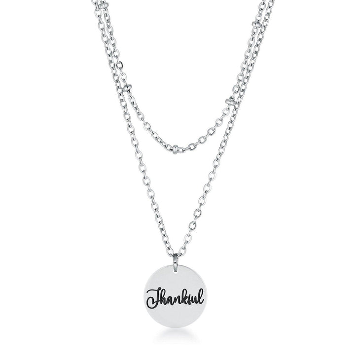 This classy necklace features a simple oval pendant inscribed with THANKFUL hanging from a cable chain. An inner saturn chain adds sophistication to
